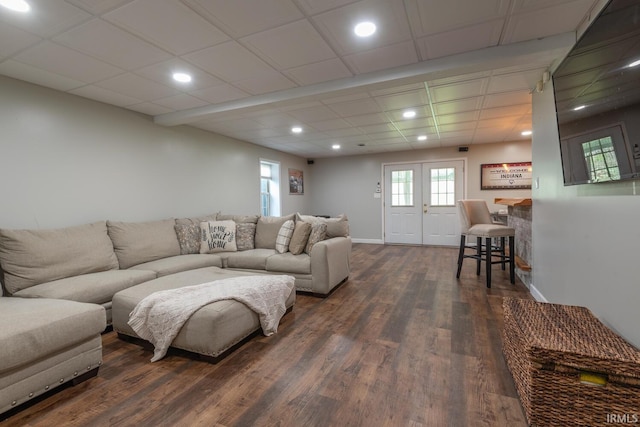 living room featuring dark wood-type flooring, baseboards, recessed lighting, and a paneled ceiling