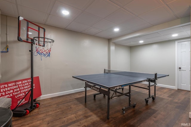 game room with baseboards, a paneled ceiling, and wood finished floors