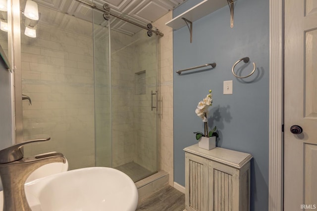 bathroom featuring a shower stall and wood finished floors