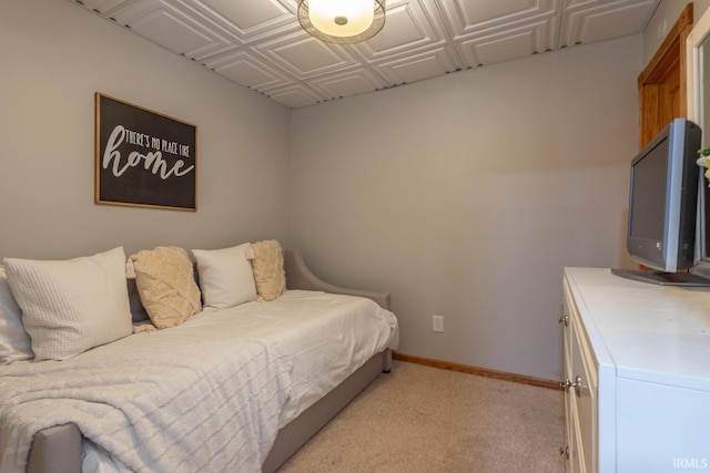 bedroom featuring an ornate ceiling, baseboards, and light colored carpet
