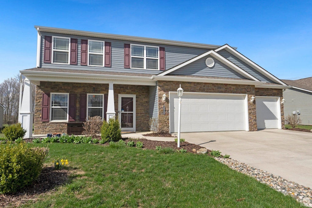view of front facade featuring a front yard, driveway, stone siding, and an attached garage