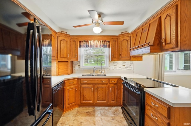 kitchen with brown cabinets, ceiling fan, a sink, and black appliances