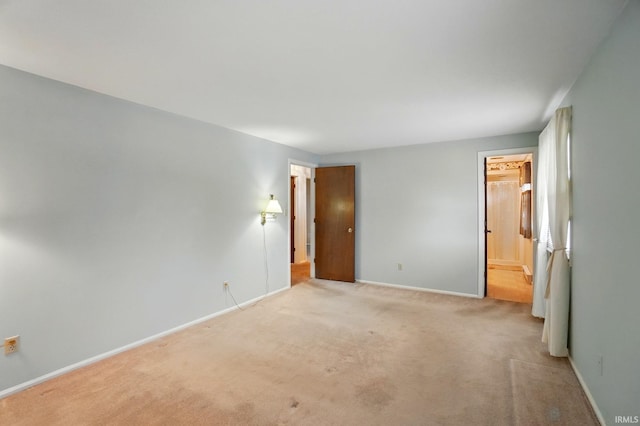 unfurnished bedroom with baseboards, carpet flooring, and connected bathroom