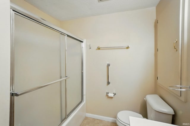 bathroom with toilet, shower / bath combination with glass door, and baseboards