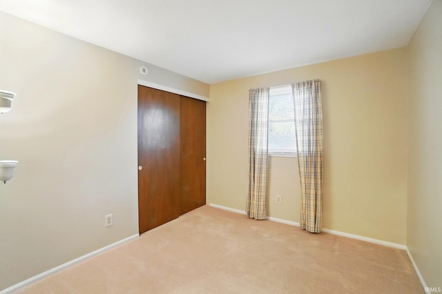 unfurnished bedroom with carpet flooring, a closet, and baseboards