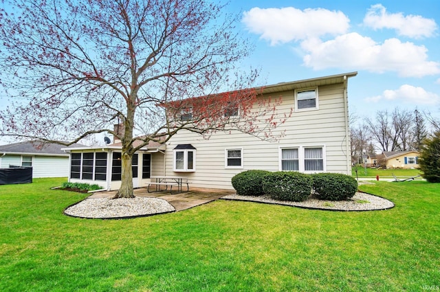 back of property with a patio area, a sunroom, and a lawn