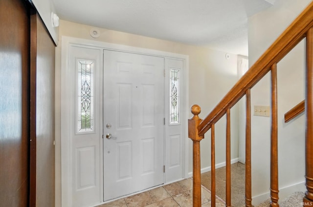 entryway with light tile patterned floors and stairway