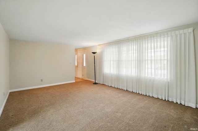 unfurnished room with carpet floors and baseboards