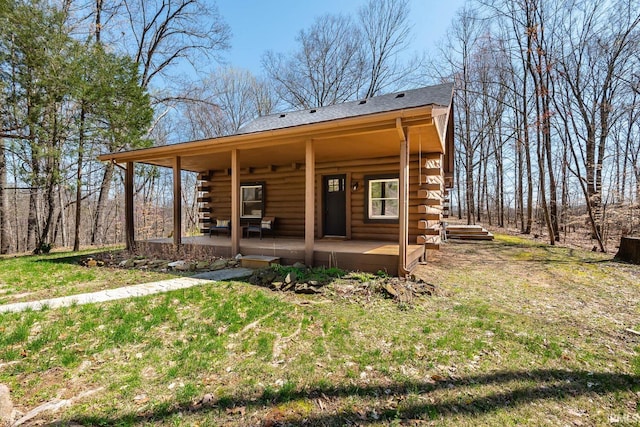 3066 N Pierce Dr, Solsberry, IN 47459 - rear view of house featuring roof with shingles, a yard, covered porch, and log exterior