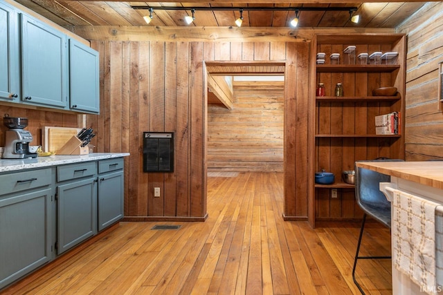 3066 N Pierce Dr, Solsberry, IN 47459 - kitchen with light wood finished floors, blue cabinets, and wood walls