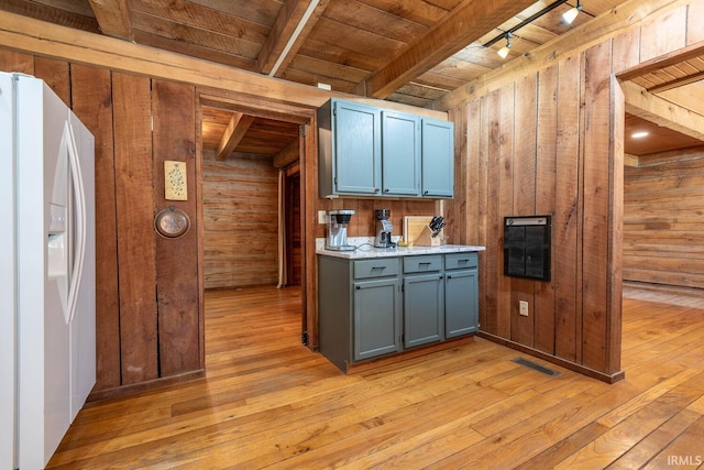 3066 N Pierce Dr, Solsberry, IN 47459 - kitchen with wood walls, light wood-type flooring, white fridge with ice dispenser, and beam ceiling