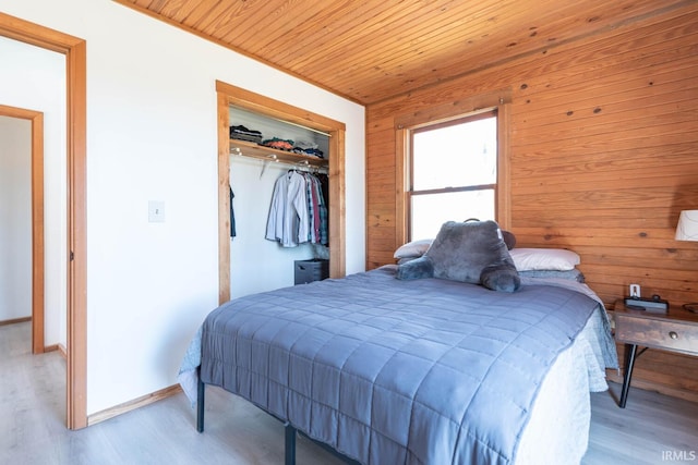 3066 N Pierce Dr, Solsberry, IN 47459 - bedroom with wood ceiling, a closet, wooden walls, and light wood-style floors