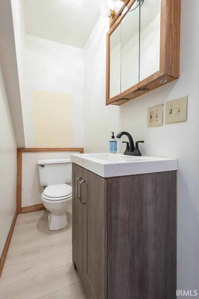 3066 N Pierce Dr, Solsberry, IN 47459 - half bath featuring vanity, baseboards, toilet, and wood finished floors
