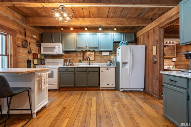 3066 N Pierce Dr, Solsberry, IN 47459 - kitchen with white appliances, wooden ceiling, light countertops, a sink, and wooden walls