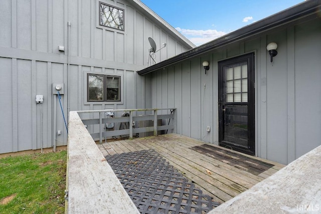 property entrance with board and batten siding and a deck