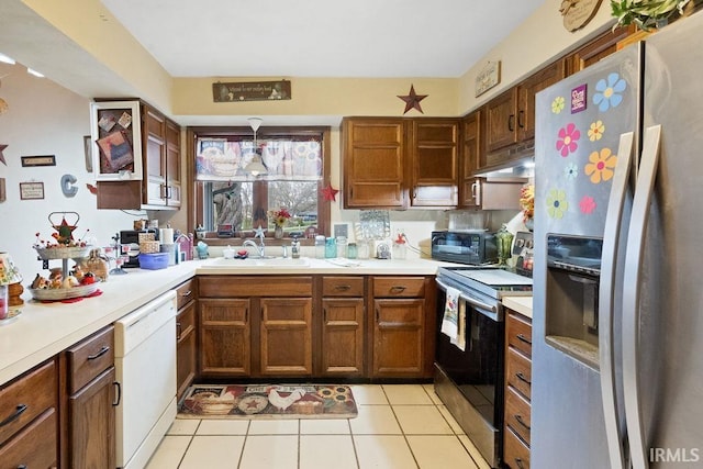 kitchen featuring light countertops, appliances with stainless steel finishes, a sink, and under cabinet range hood
