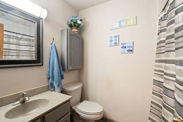 bathroom featuring toilet, curtained shower, and vanity