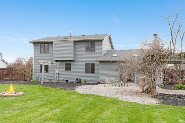 back of property with a fire pit, a patio area, central air condition unit, fence, and a yard