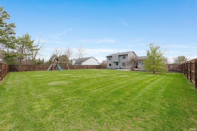view of yard with a fenced backyard and a playground