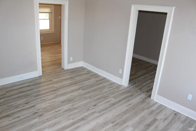 unfurnished room with baseboards and wood finished floors