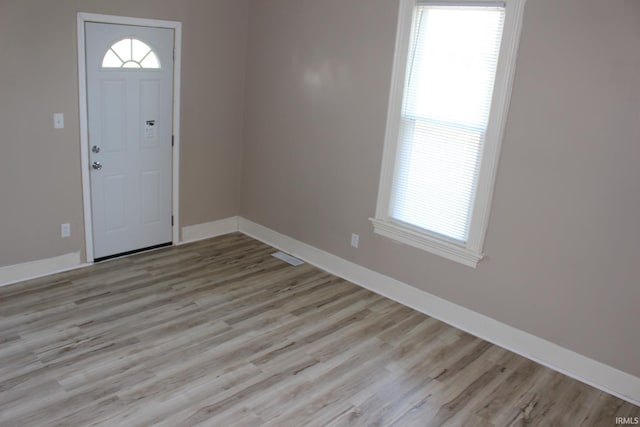 foyer entrance with plenty of natural light, light wood-style flooring, and baseboards