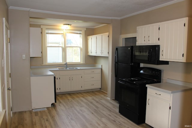 kitchen with light countertops, light wood-type flooring, a sink, and black appliances