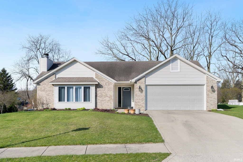 view of front of home with a front yard, a garage, a chimney, concrete driveway, and brick siding