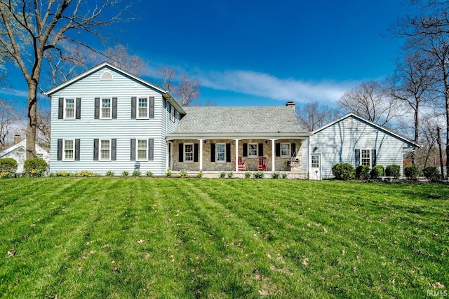 view of front of house with a porch, a chimney, and a front yard