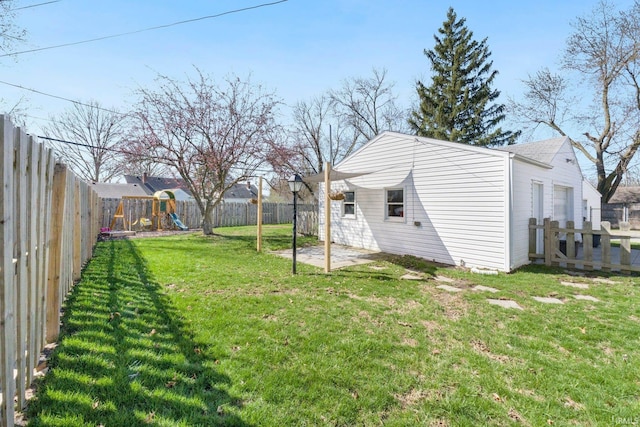 view of yard featuring a fenced backyard, a playground, and a patio area