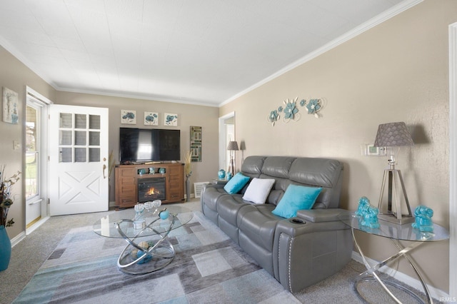 living room featuring a lit fireplace, ornamental molding, visible vents, carpet floors, and baseboards