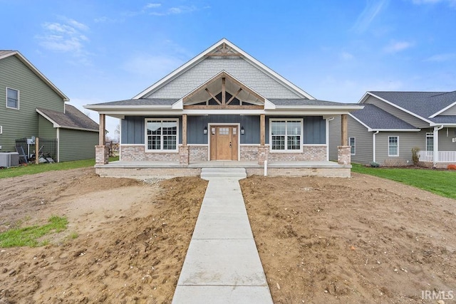 craftsman house with board and batten siding, a porch, and central AC unit