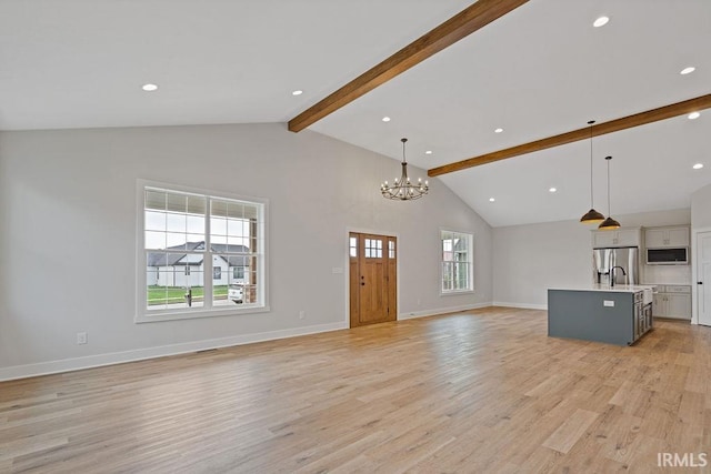 interior space featuring light wood-type flooring, recessed lighting, a chandelier, baseboards, and beam ceiling
