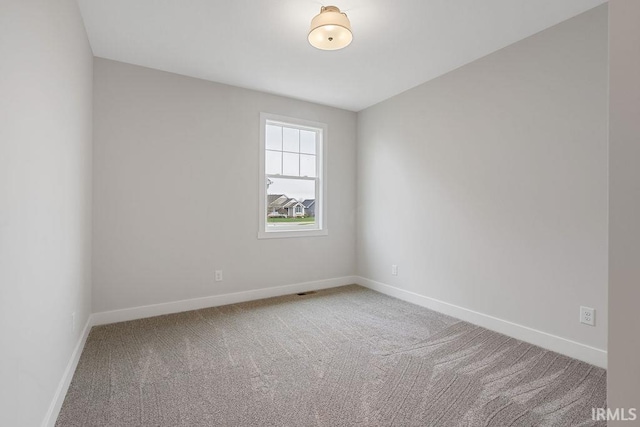 carpeted spare room with baseboards