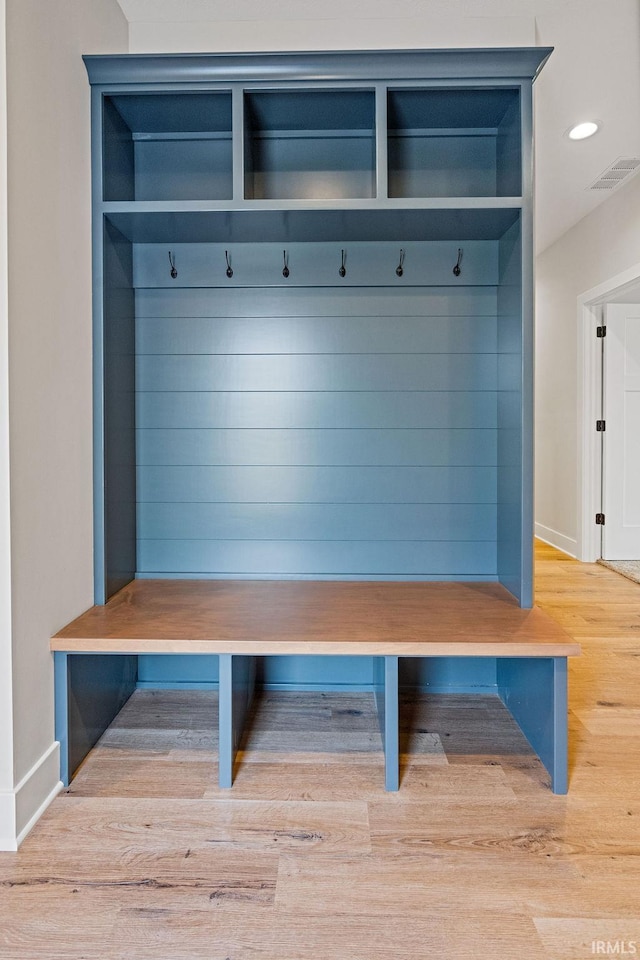 mudroom featuring visible vents, baseboards, and wood finished floors