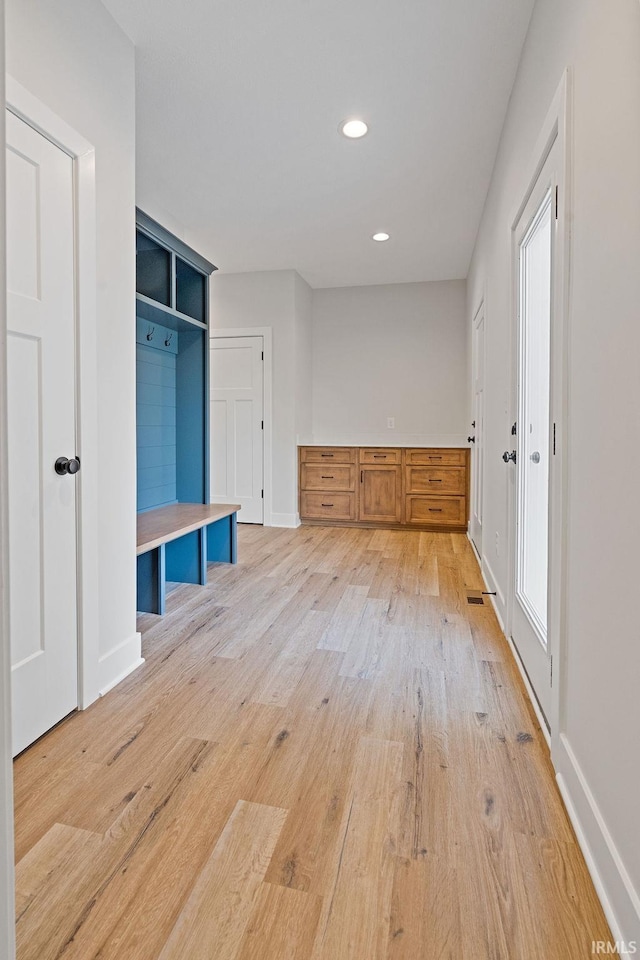 mudroom with recessed lighting, light wood-style flooring, and baseboards