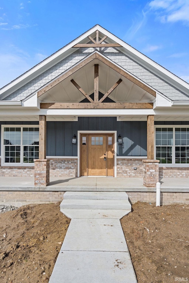 view of exterior entry featuring covered porch