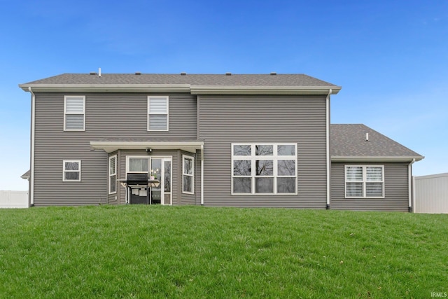rear view of house featuring a lawn