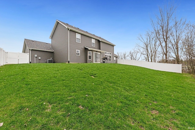 back of house featuring a fenced backyard, cooling unit, and a lawn