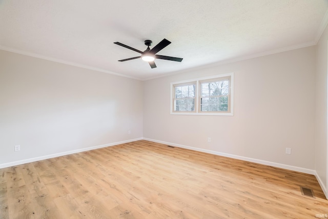 spare room featuring crown molding, visible vents, baseboards, and light wood finished floors