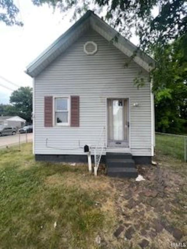 back of house featuring entry steps and a lawn