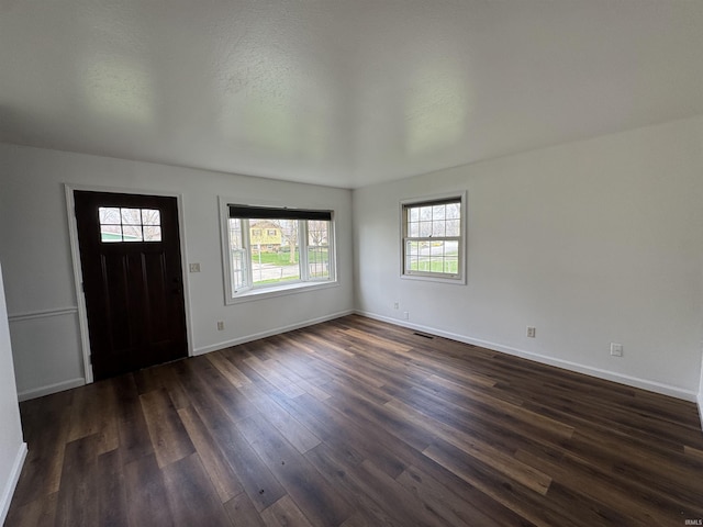 foyer entrance featuring dark wood-type flooring and baseboards