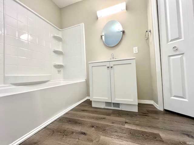 full bath with wood finished floors, vanity, and baseboards