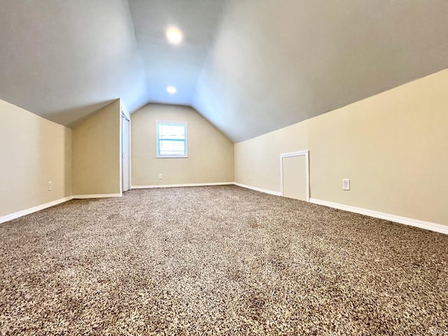 additional living space with baseboards, carpet, and vaulted ceiling