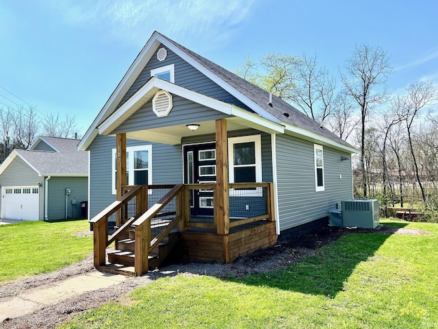 view of front of property featuring a garage, a porch, central AC unit, and a front lawn