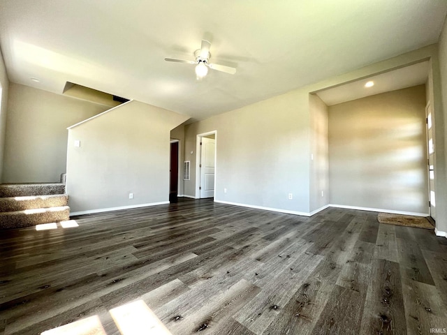 unfurnished living room featuring wood finished floors, baseboards, a ceiling fan, and stairway