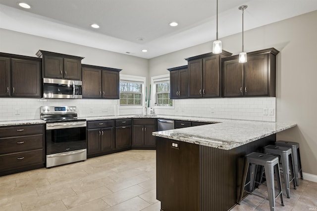 kitchen with tasteful backsplash, dark brown cabinetry, a peninsula, and appliances with stainless steel finishes
