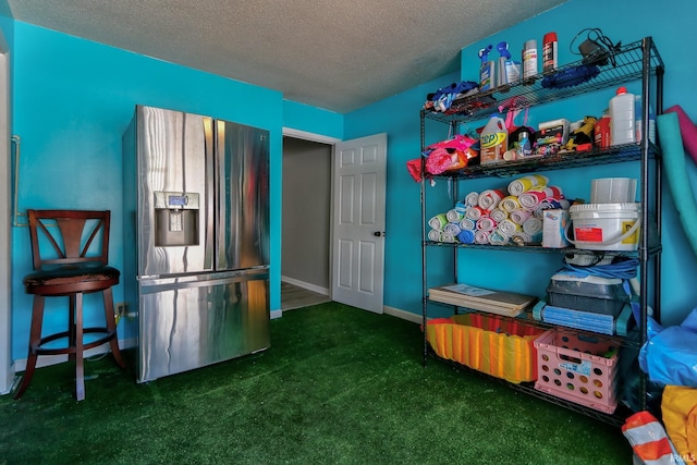 interior space featuring carpet floors, baseboards, stainless steel refrigerator with ice dispenser, and a textured ceiling