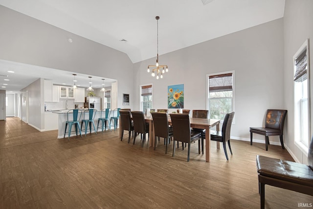 617 Pearl St, Culver, IN 46511 - dining room with dark wood-style flooring, high vaulted ceiling, a notable chandelier, and a healthy amount of sunlight
