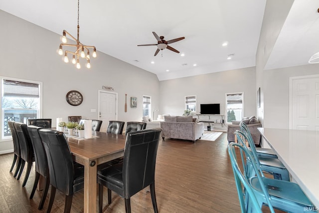 617 Pearl St, Culver, IN 46511 - dining room with a healthy amount of sunlight, ceiling fan with notable chandelier, high vaulted ceiling, and dark wood-style flooring