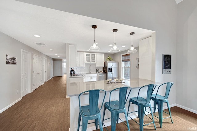 617 Pearl St, Culver, IN 46511 - kitchen featuring glass insert cabinets, visible vents, a breakfast bar, stainless steel appliances, and baseboards